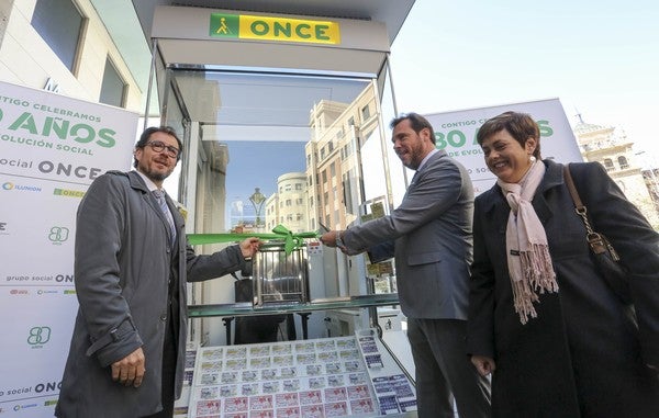 Rosa María Martín (D), jefa del departamento de juego de la ONCE CYL, Ismael Pérez Blanco (I), delegado regional de la ONCE, Castilla y León y Oscar Puente (C), alcalde de Valladolid, durante la inauguración de un nuevo modelo de kiosko en la calle Santiago de Valladolid. 