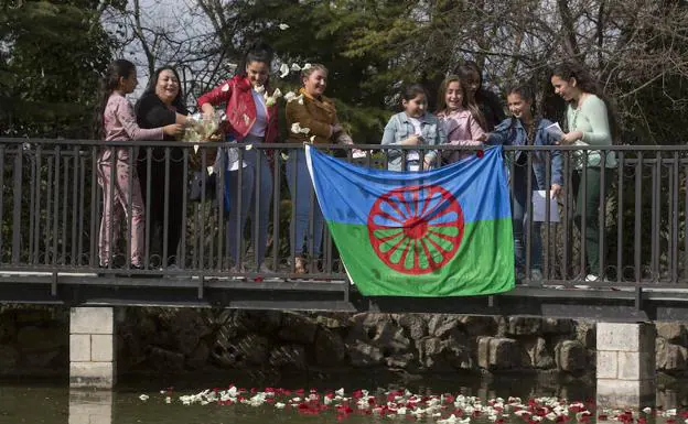 Jóvenes gitanas arrojan pétalos al estanque del parque Ribera de Castilla en la 'Ceremonia del río'. 