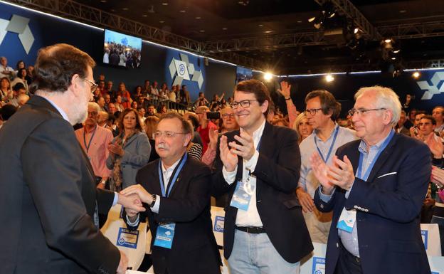 El presidente del PP de Castilla y León, Alfonso Fernández Mañueco (centro), saluda a Mariano Rajoy antes de intervenir en la mesa Diálogos Populares en la Convención Nacional.