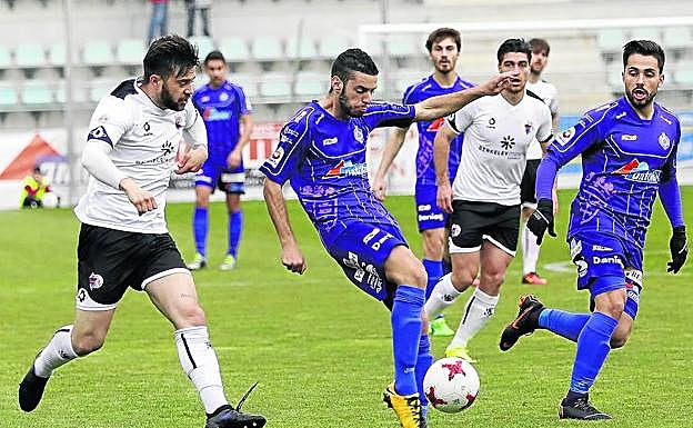 Adrián se dispone a disparar ante la presión de varios rivales del Salmantino, ayer en La Balastera.