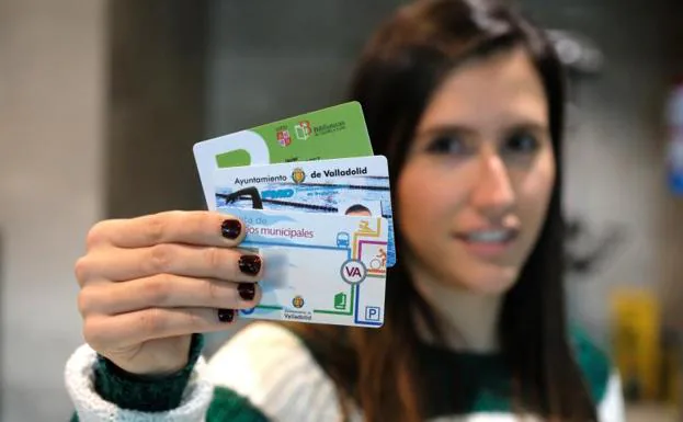 Una joven muestra tres de las tarjetas que hay que utilizar ahora para otros tantos servicios municipales.