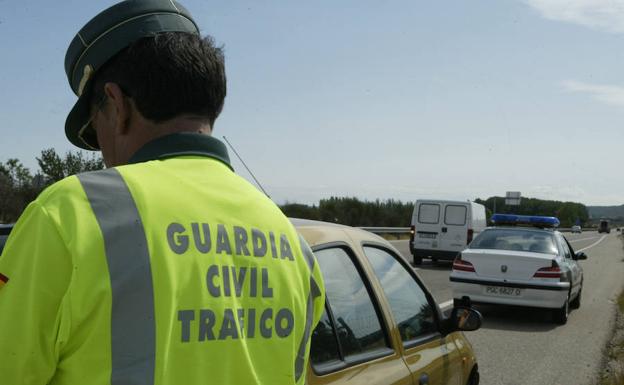 Un guardia civil de Tráfico sanciona a un conductor por una infracción. 