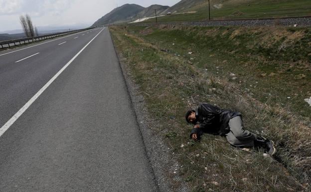 Un migrante afgano descansa en la cuneta de la carretera antes del accidente. 