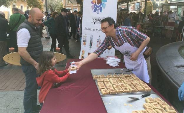 Una niña recibe un pastel en el estand de la Asociación de Confiteros de Valladolid. 