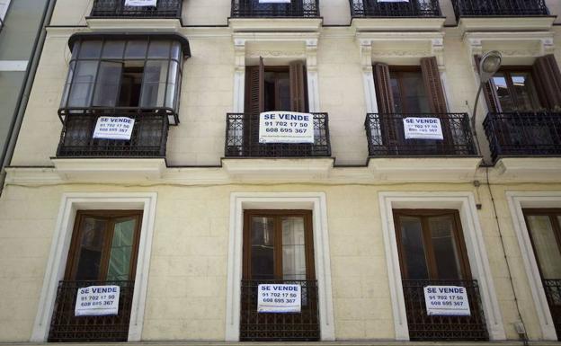 Bloque de apartamentos del centro de Madrid con carteles de «Se Vende» en casi todas las viviendas.