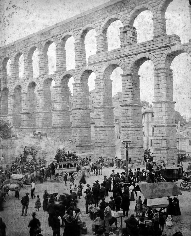 El Azoguejo junto al Acueducto siempre ha sido uno de los espacios más bulliciosos. En esta fotografía de 1888, pueden verse las diligencias y carruajes que a diario lo cruzaban, así como la farola de petróleo que lo alumbraba por las noche.