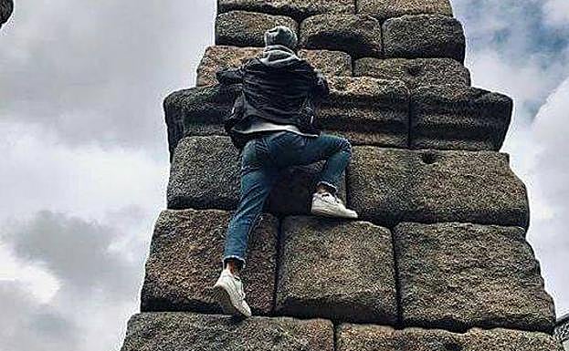 Un hombre trepa por uno de los pilares del Acueducto de Segovia.