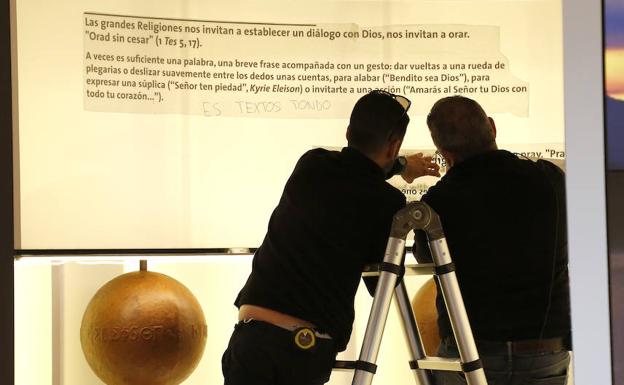 Dos operarios ultiman los remates de la exposición.