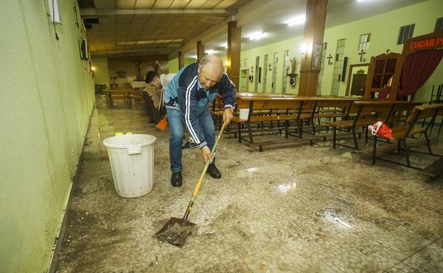 Un vecino limpia la iglesia de Fátima tras el aguacero.