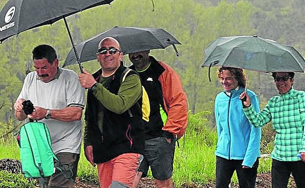 Un grupo de andarines cobijados bajo sus paraguas. 