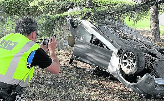 Un policía local toma fotografías del vehículo accidentado en Cardenal Cisneros. 