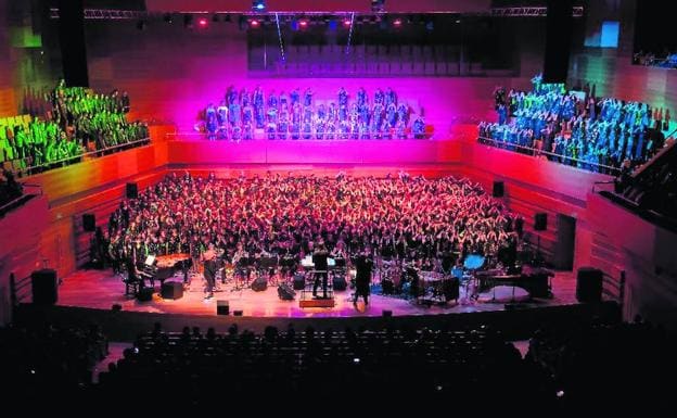 Los coros infantiles de colegios de localidades de Castilla y León ocupan el escenario, los palcos laterales y el fondo del Auditorio. 