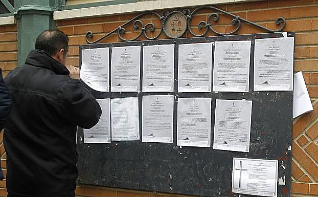 Un hombre mirando esquelas.