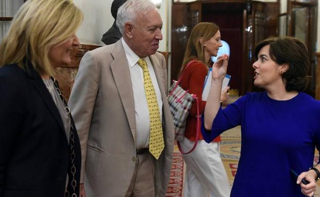 La exvicepresidenta del Gobierno y candidata a liderar el PP, Soraya Sáenz de Santamaría (d), conversa con el también candidato a liderar el PP, eL exministro de Asuntos Exteriores y de Cooperación del Gobierno José Manuel García-Margallo (c), y la exministra de Empleo y Seguridad Social, Fátima Báñez (i), a su salida del pleno del Congreso celebrada en Madrid. 