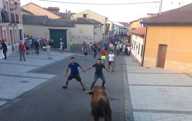Los aficionados Adrián Tejero y Daniel Santaolaya reciben al toro desde el cajón.