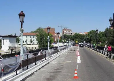 Imagen secundaria 1 - A la izquierda el Puente Mayor que ya muestra la nueva valla para proteger a los peatones. A la derecha, los carteles obra para renovar el asfalto. 