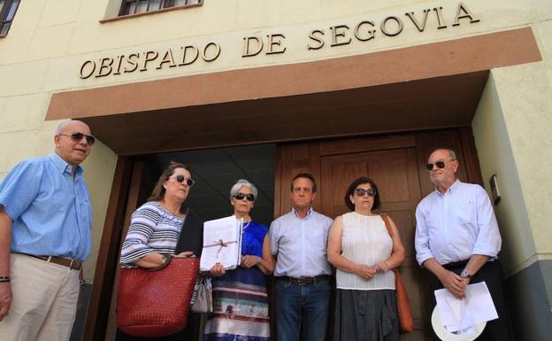 Vecinos de El Espinar muestran las firmas a la entrada del Obispado de Segovia. 