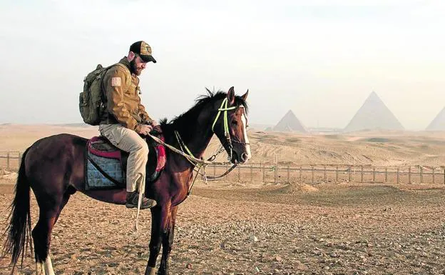 A caballo, en un alto en el camino durante una de sus aventuras en Egipto, con las pirámides al fondo.