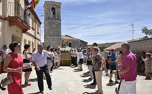 Los vecinos bailan al paso de la imagen en una edición pasada de las fiestas. 