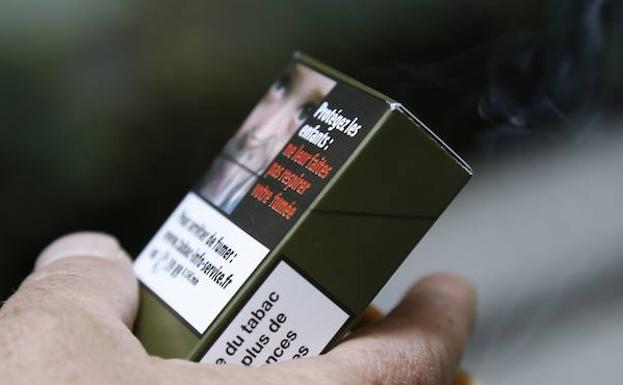 Un hombre sujeta una cajetilla de tabaco.
