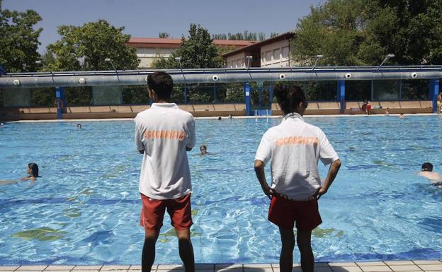 Dos socorristas prestan servicio en una piscina municipal. 