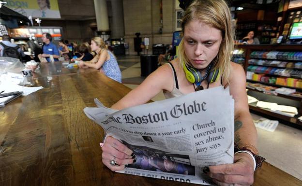 Lauren Vowells, una residente de Boston, Massachusetts, lee un ejemplar de 'The Boston Globe'