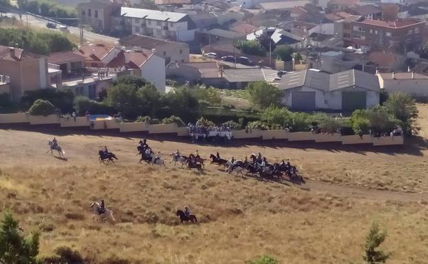 Los caballistas atraviesan el campo encauzando a las reses.