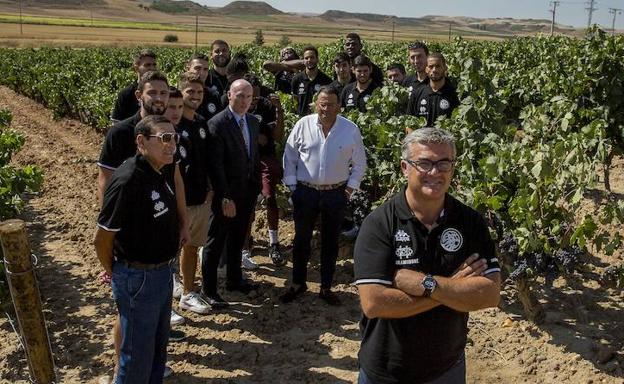 Paco García, en primer plano, Mike Hansen, Óscar Mendiluce y la plantilla del Carramimbre posan en los viñedos que tiene la bodega en Peñafiel. 