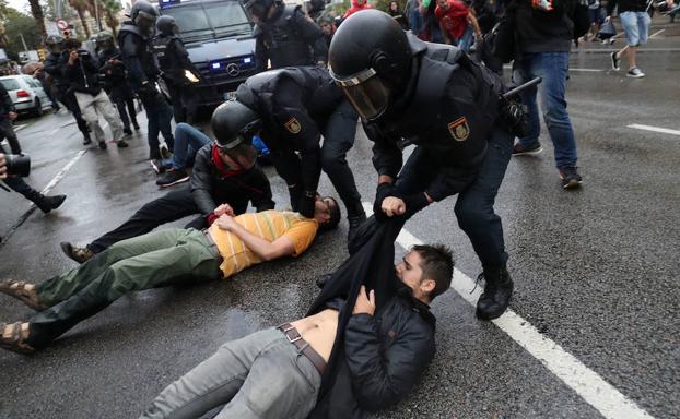 Agentes de la Policía nacional arrastrando a ciudadanos que trataban de evitar su entrada a un centro electoral en Barcelona, durante el referéndum catalán del 1-O. 