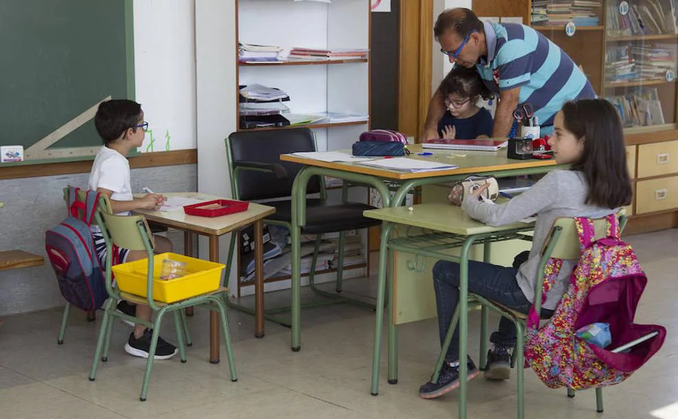 El tutor del aula de Villalba de la Lampreana, Pepe Domínguez, junto a los tres alumnos en clase. 