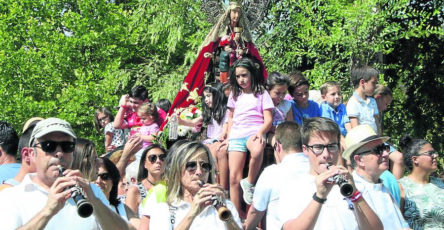 Un grupo de niños desfilan bajo el manto de la Virgen.