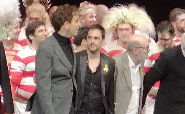 Foto del instante en que varios miembros del equipo saludan al público.