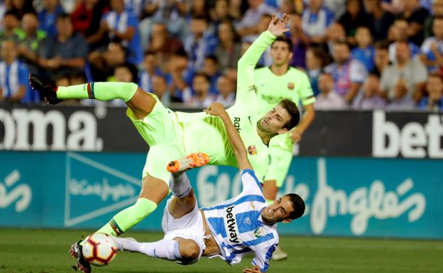 Gerard Piqué lucha por el balón frente al delantero del Leganés, Sabin Merino