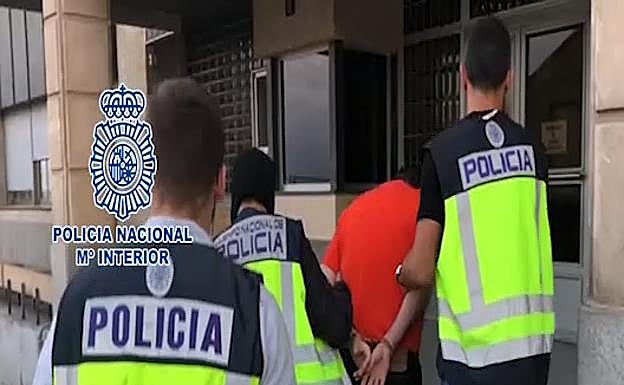 Tres agentes del Cuerpo Nacional de Policía trasladan esposado a Esteban Vacas tras su detención en el barrio del Carmen.