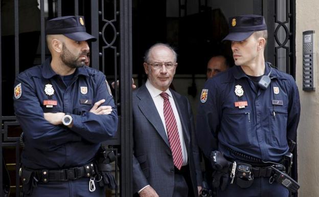 Rodrigo Rato sale de su oficina de Madrid acompañado de agentes de Plicía en abril de 2015.