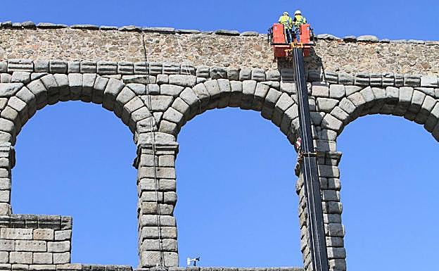Dos técnicos colocan los sensores en la parte alta del Acueducto. 