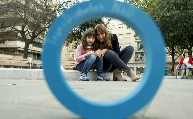 Adriana, de 6 años, junto a su madre, Laura García, con el círculo azul que simboliza la diabetes.