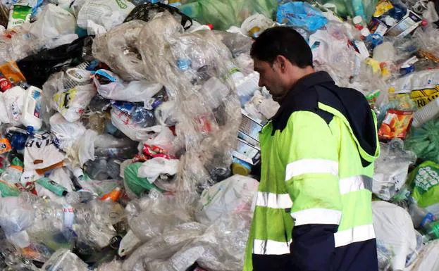 Un operario del centro de Los Huertos ante un montón de basura depositada para su tratamiento