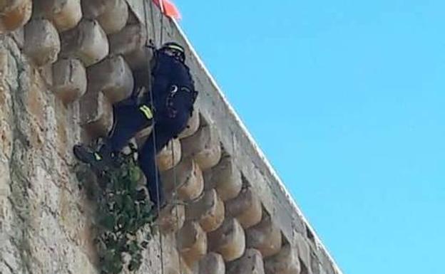 Un bombero desciende por el castillo. 