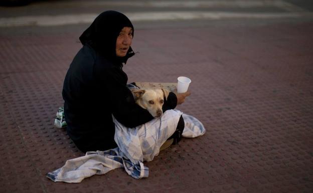 Una mujer pide limosna en una calle de Málaga. 