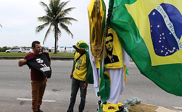 Un hombre negocia con el vendedor la compra de una camiseta de Jair Bolsonaro.
