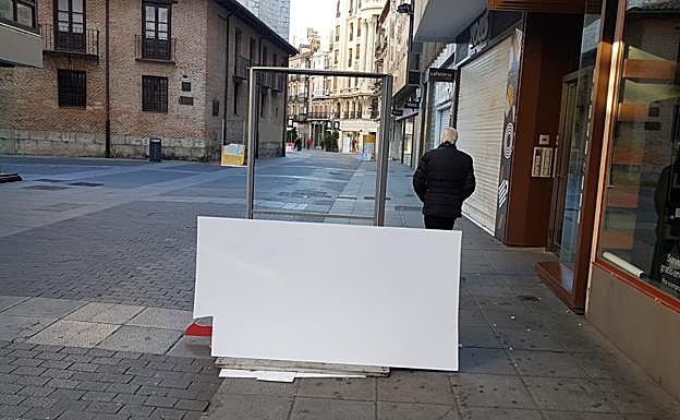 Imagen principal - Carteles destrozados en la calle Santiago de Valladolid. 