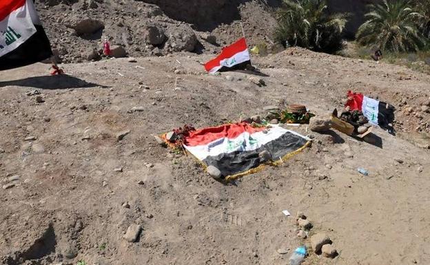 Banderas iraquíes sobre supuestas fosas comunes de víctimas del Estado Islámico, en Tikrit. 