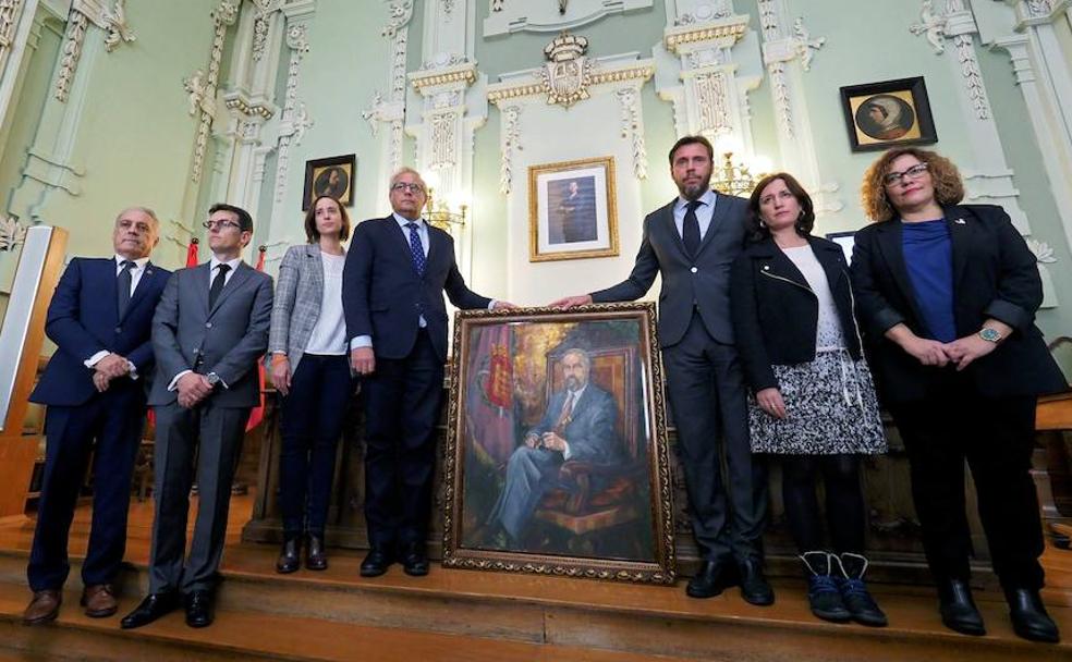 Puente sostiene el retrato de Rodríguez Bolaños durante el pleno extraordinario en su honor. 