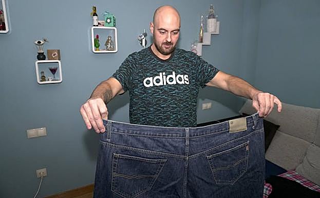 Diego Hernández, de 31 años, muestra su talla de pantalón antes de la reducción de estómago, tras perder 90 kilos en un año. 