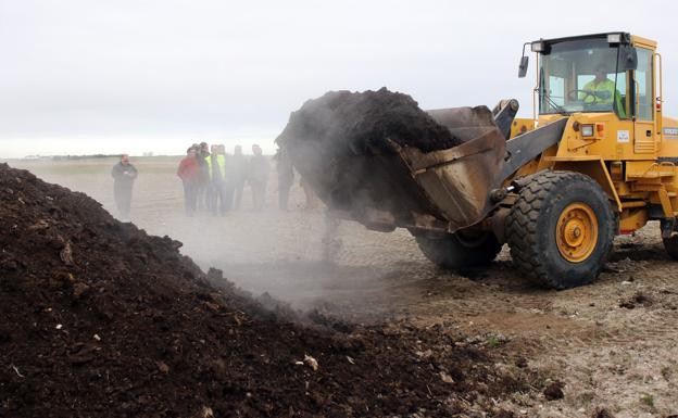 Una máquina recoge residuos de uno de los montones de la planta de compostaje de Fuentepelayo. 