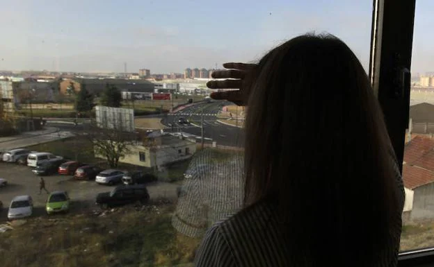 Una mujer víctima de violencia machista mira al horizonte a través de una ventana en Valladolid. 