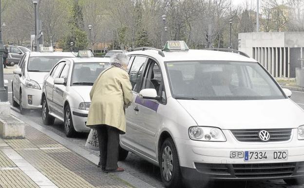 Una viajera se dispone a subir a un taxi en la plaza Juan de Austria. 