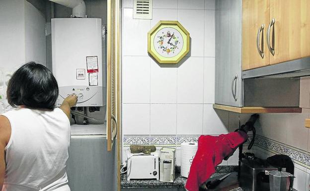 Una mujer regula su caldera individual en su domicilio.