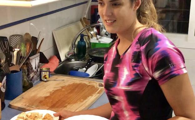 Lía Beel posa con dos platos de salmón en la cocina de su casa en Madrid. 